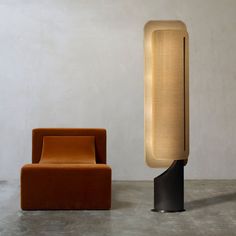 an orange chair next to a black and gold lamp