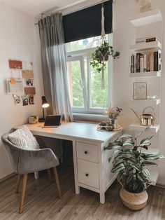 a home office with a desk, chair and potted plant in front of the window