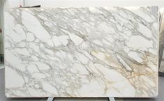 a large white marble slab sitting on top of a metal stand