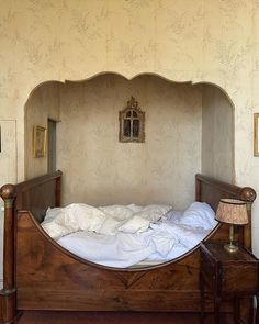 an old fashioned bed with white sheets and pillows