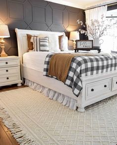 a white bed sitting in a bedroom on top of a wooden floor next to a window