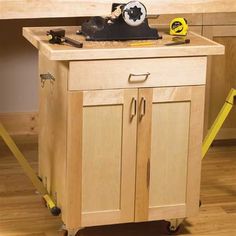 a workbench with tools on it in the middle of a wooden floored room