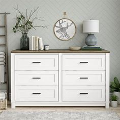 a white dresser with books and plants on top