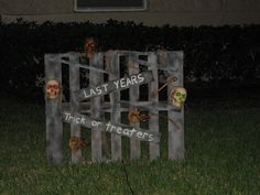 a sign that says last years and there is a skeleton in the yard behind it