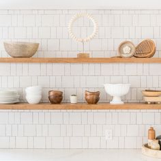 the shelves are filled with bowls and plates on them, along with other kitchen utensils