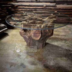 a table made out of wood and glass with an interesting design on the top, surrounded by stacks of lumber