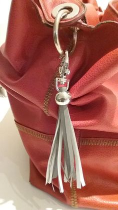 a red purse with a tassel hanging from it