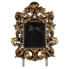 an ornate gold frame with black marble in the center and scrolling scrolls around it, against a white background