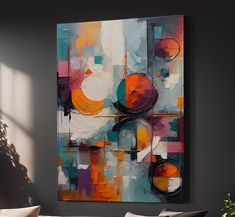 an abstract painting hangs on the wall above a couch in front of a potted plant