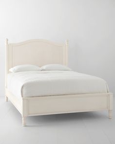 a white bed sitting on top of a white floor