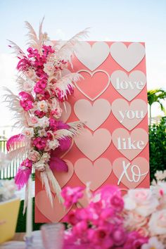 a pink and white sign that says i love you like 80 next to some flowers