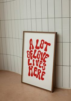 a red and white sign sitting on top of a counter next to a tiled wall