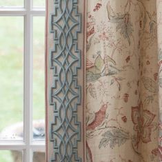 a curtain with an intricate design hanging from it's side next to a window