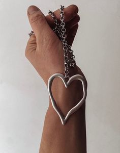 A stylish symbol of love and strength, this statement heart necklace offers an instant style upgrade. Using a lightweight but sizeable rolo chain and distinctive large, hollow heart pendant, the piece is an antique silver tone with a dull matte finish offering a more casual and bohemian feel.  ▪️Silver plated brass ▪️Heart measures 65mm ▪️Rolo chain - 8mm thickness ▪️Lobster clasp ▪️Comes in Scraffs gift packaging Trendy Silver Open Heart Necklace, Silver Metal Heart Pendant Necklace, Metal Heart Necklace With Open Heart Charm, Silver Heart Necklace With Large Pendant, Silver Open Heart Metal Necklace, Heart-shaped Chunky Chain Necklace Gift, Chunky Metal Heart Pendant Necklace, Silver Heart Necklace With Oxidized Finish, Grunge Heart-shaped Metal Necklace