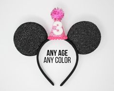 a mickey mouse ears hat with the number one on it's head, says any age is an awesome color