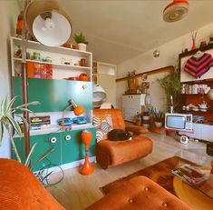 a living room filled with orange furniture and lots of clutter on top of it