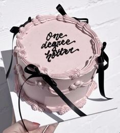 a person holding a cake with writing on it and ribbon around the edge that says, one negative sister