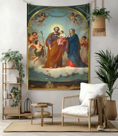 an image of the virgin mary and child jesus hanging in a living room with potted plants