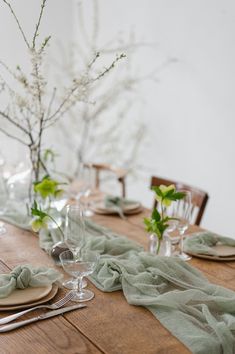 a wooden table topped with plates and glasses