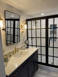 a bathroom with double sinks and large mirrors on the wall, along with glass doors leading outside