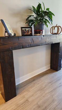 a wooden table sitting on top of a hard wood floor next to a potted plant