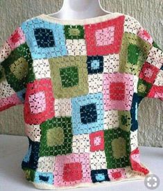 a crocheted sweater with squares and circles on it