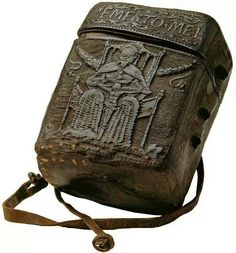 an old metal box with carvings on the front and sides, attached to a chain