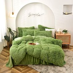 a green comforter and pillows in a room