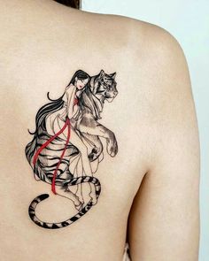 a woman with a tiger tattoo on her back and the image of a cat sitting on top of it