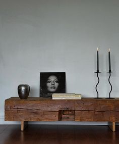 a wooden table with two candles and a photograph on it next to a candle holder