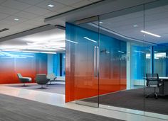 an empty office with glass walls and chairs