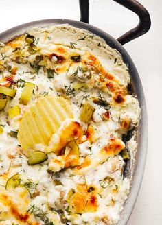 a pan filled with potatoes and cheese on top of a stove