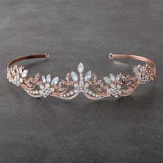 a bridal headband with crystal stones and leaves on the side, sitting on a gray surface