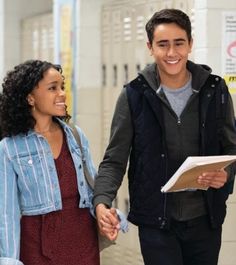 a man and woman holding hands in a hallway