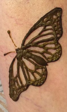 a close up of a person's leg with a butterfly tattoo on it