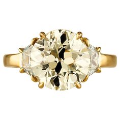 an old mine cut diamond engagement ring with three stone accents on the band and side stones in yellow gold