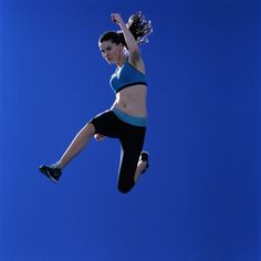 a woman jumping in the air with her feet up