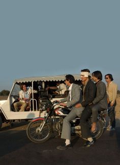 several men riding on the back of a motorcycle