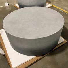 two round concrete tables sitting on top of pallets