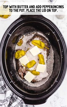 a pot with butter and pepperonis in it on top of a table next to wine glasses