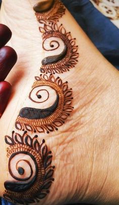 a woman's foot with henna tattoos on it