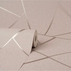 a roll of toilet paper sitting on top of a white tiled floor next to a wall