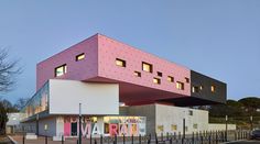 a pink and white building sitting on the side of a road