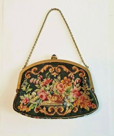 an old purse hanging from a chain with flowers on the front and bottom, as if it were beaded