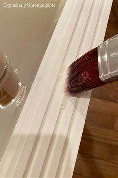 a paintbrush is being used to paint the side of a bathtub