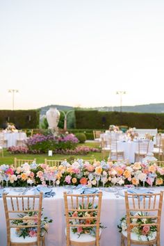 the tables are set with flowers and chairs