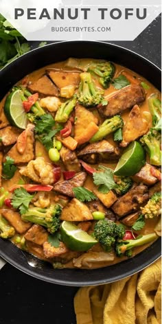 a pan filled with chicken, broccoli and other vegetables in peanut tofu