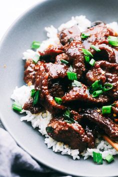 a close up of a plate of food with rice and meat on it's side