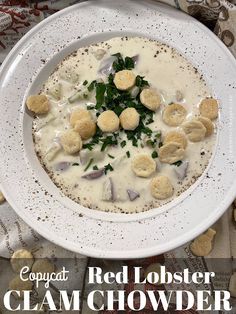 a white bowl filled with clam chowder next to crackers