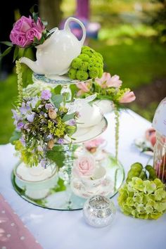 an image of a table setting with flowers and teapots on it, in arabic